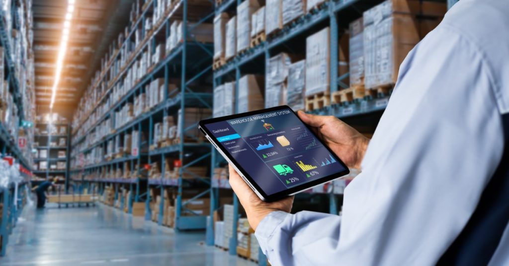 A close-up of someone in a smart Warehouse using their Inventory management system on a tablet while checking inventory.
