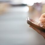 A close-up of a professional warehouse staff member using a digital tablet to review the stock inventory on the shelf.